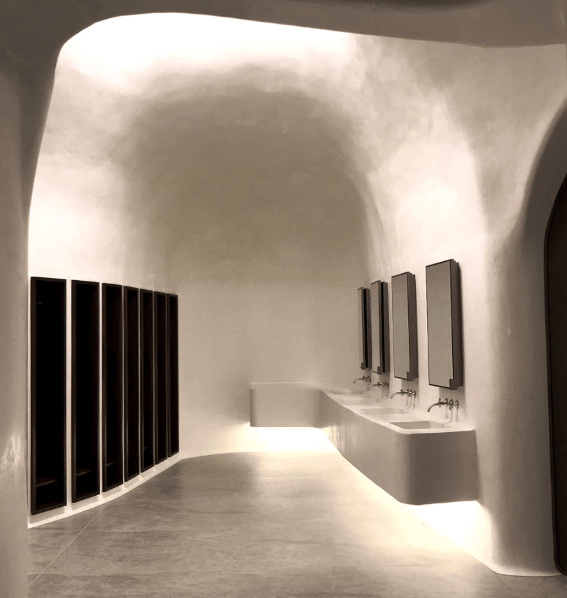 Omklädningsrum i tadelakt med integrerade tvättställ och mjuka former.